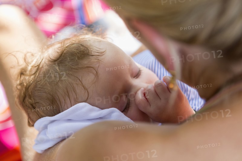 Caucasian mother cradling baby