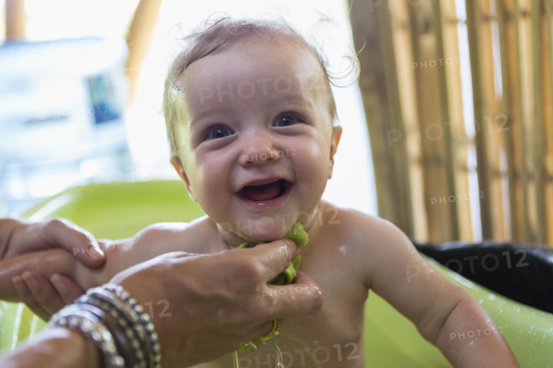 Caucasian mother washing baby in plastic tub