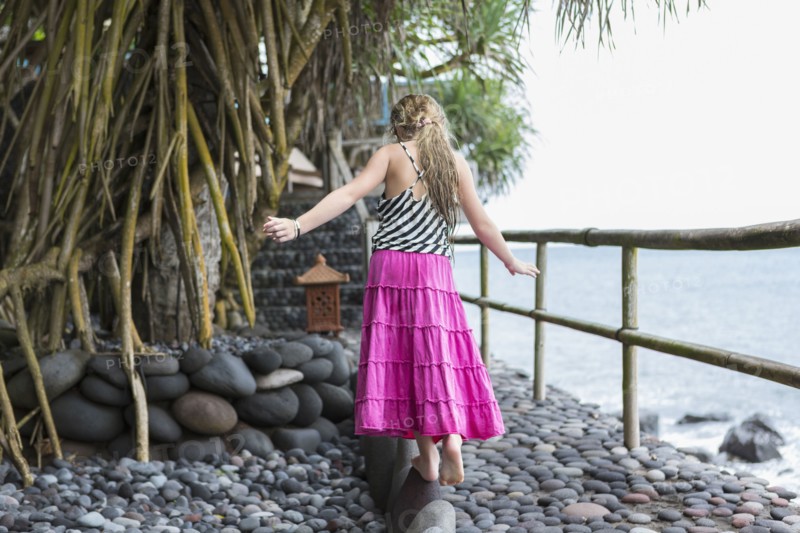 Caucasian girl walking along stone ledge