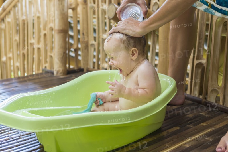 Caucasian baby having bath in tub