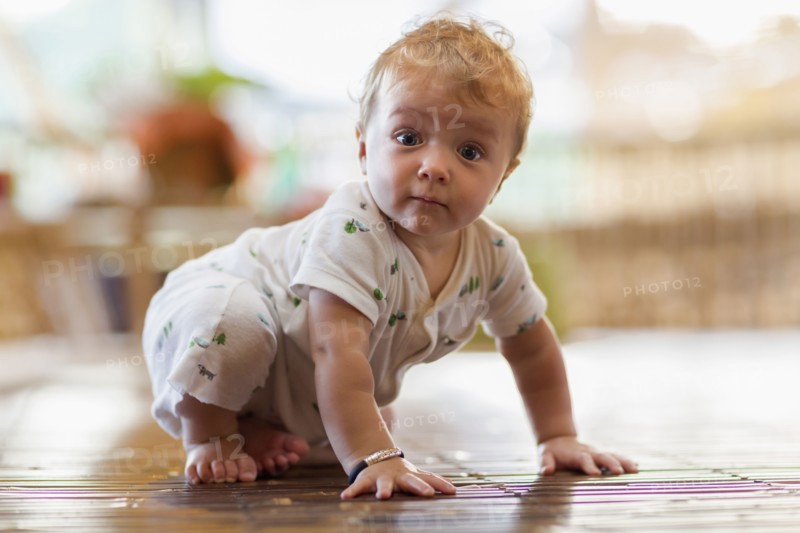 Caucasian baby crawling on floor