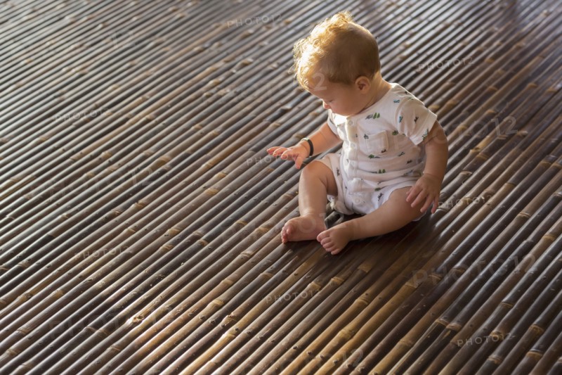 Caucasian baby playing on bamboo floor