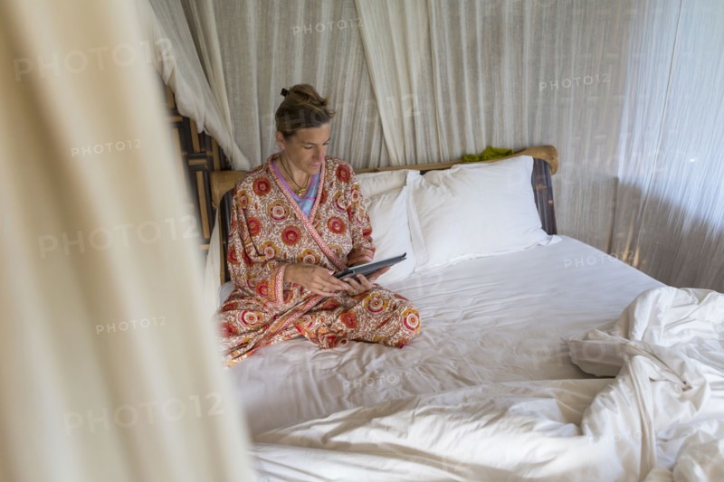 Caucasian woman using digital tablet in bed