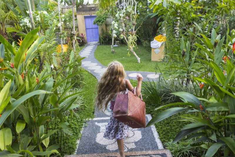 Caucasian girl carrying purse on stone backyard steps