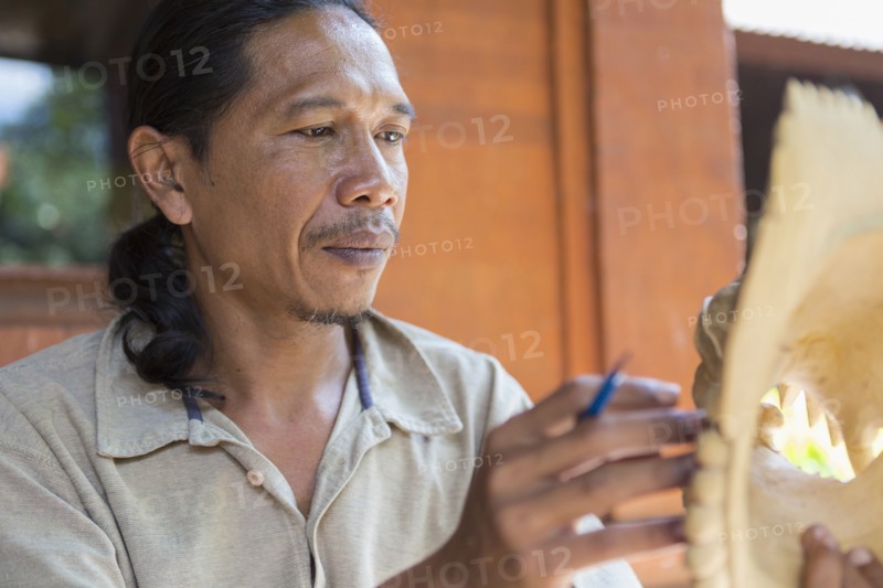 Wood worker examining piece in studio