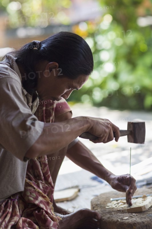 Wood worker chiseling piece in studio