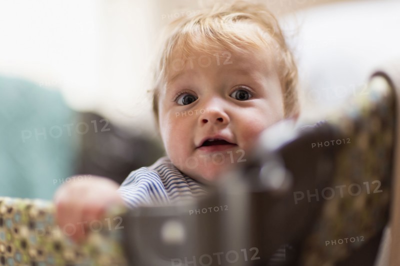 Caucasian baby standing in laundry basket