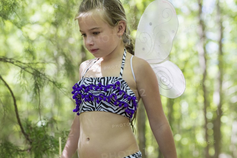 Caucasian girl playing dress up in forest
