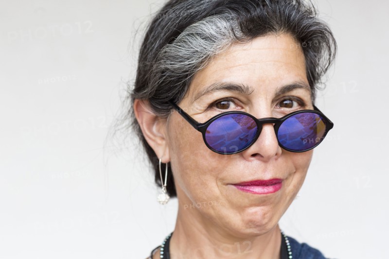 Older Hispanic woman wearing blue sunglasses