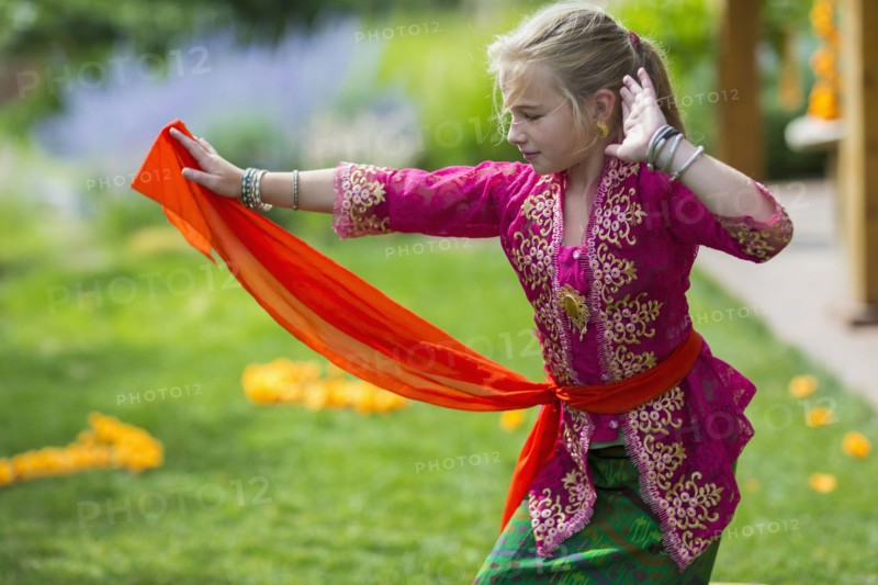 Caucasian girl performing Balinese dance in backyard