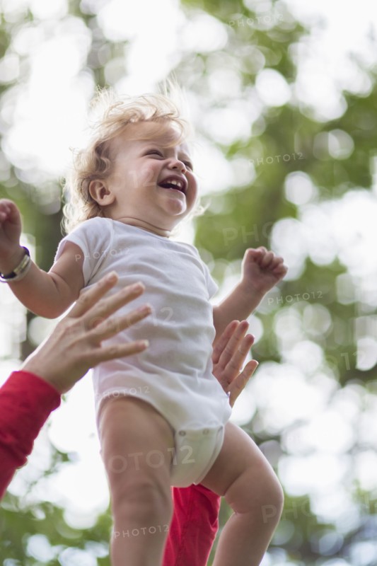 Caucasian mother playing with baby boy outdoors