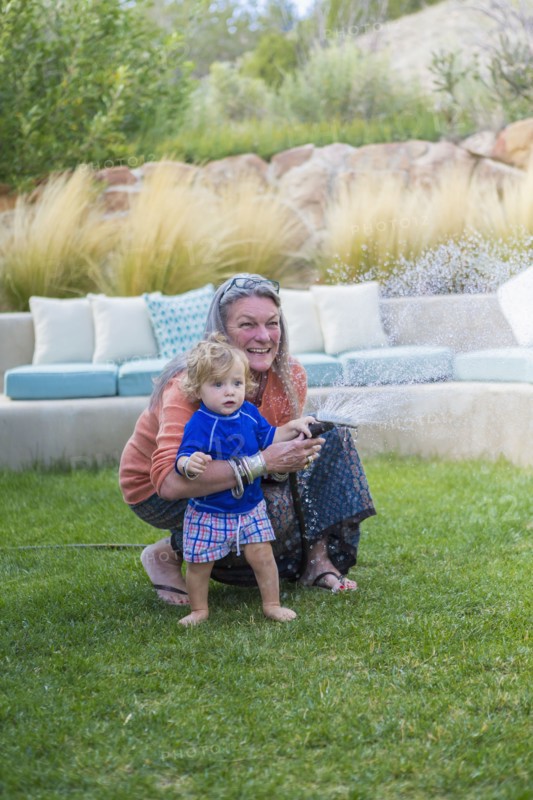 Caucasian grandmother hugging baby grandson in backyard