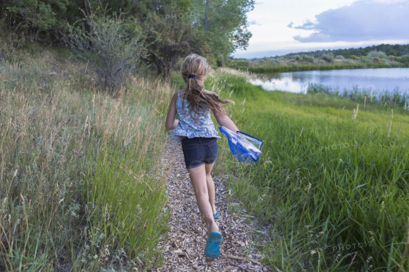 Caucasian girl running on path near tall grass