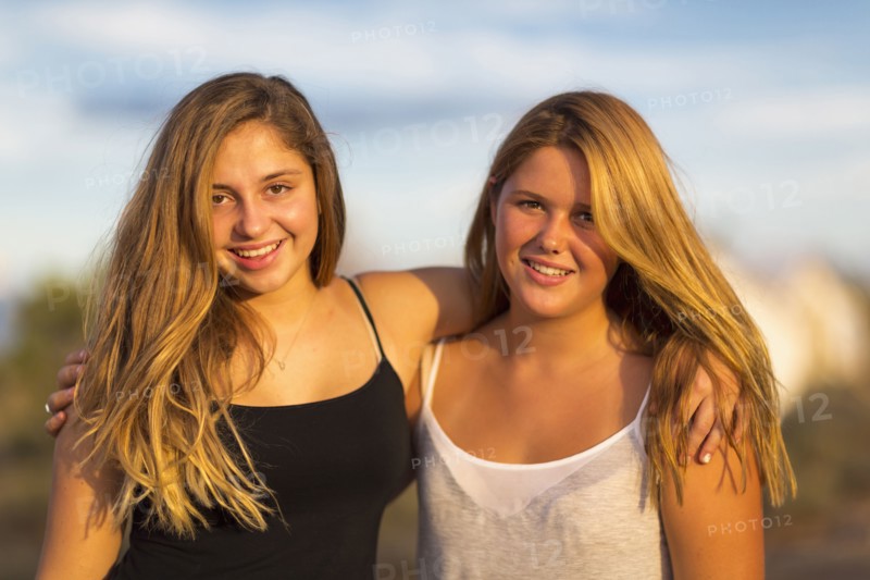 Teenage girls hugging outdoors