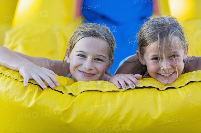 Caucasian girls playing together on inflatable castle