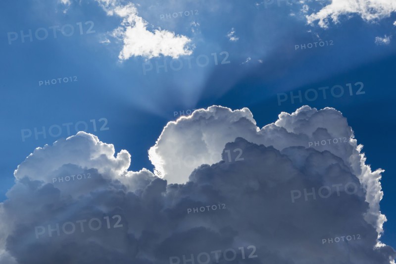 Sunbeams shining through clouds in blue sky