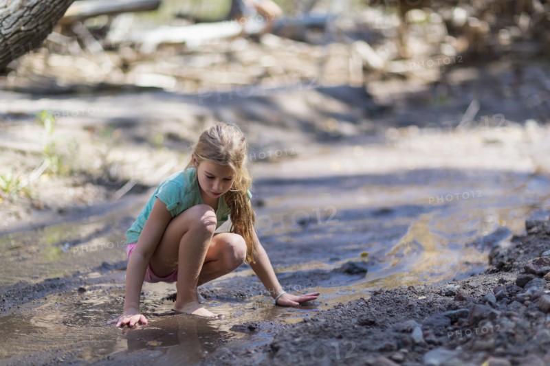 Caucasian girls exploring creek in forest