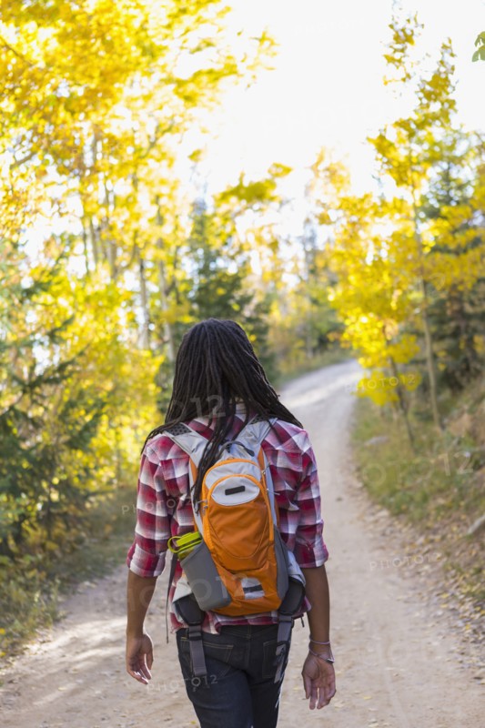 Mixed race man hiking in forest