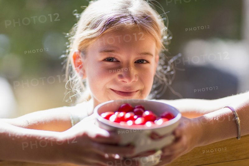 Caucasian girl holding bowl of fruit