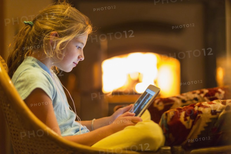 Caucasian girl using digital tablet in living room