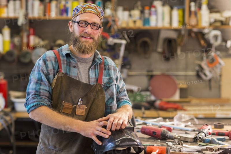 Caucasian craftsman smiling in workshop