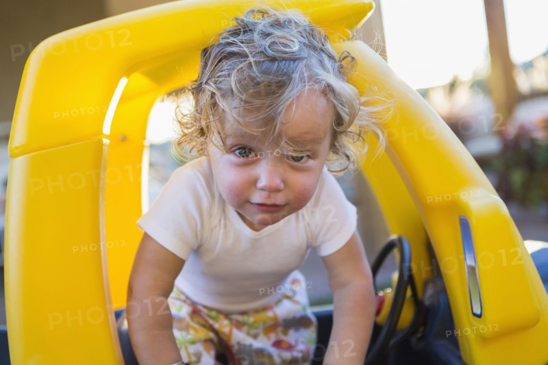 Caucasian boy playing in toy car