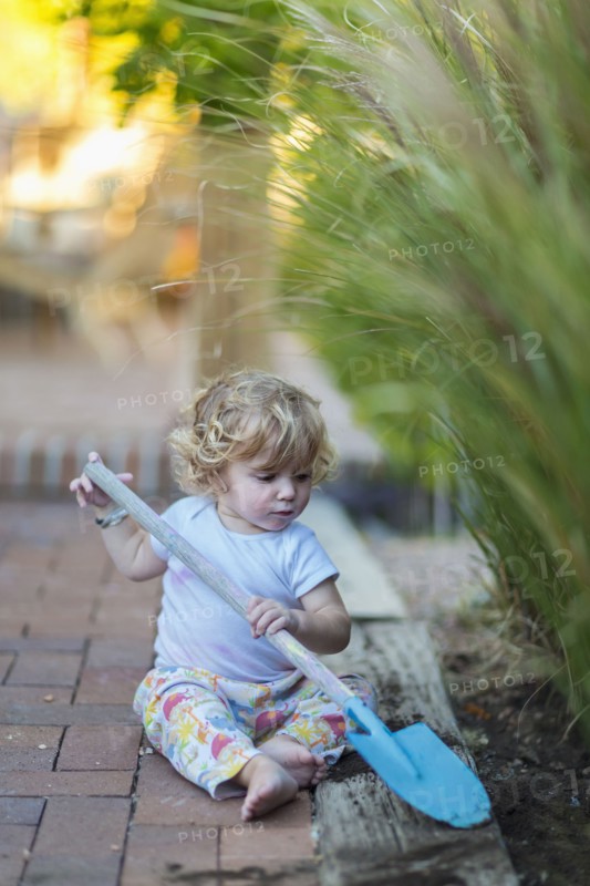 Caucasian boy playing with spade in garden