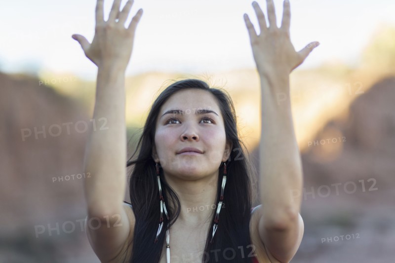Mixed race woman meditating in desert