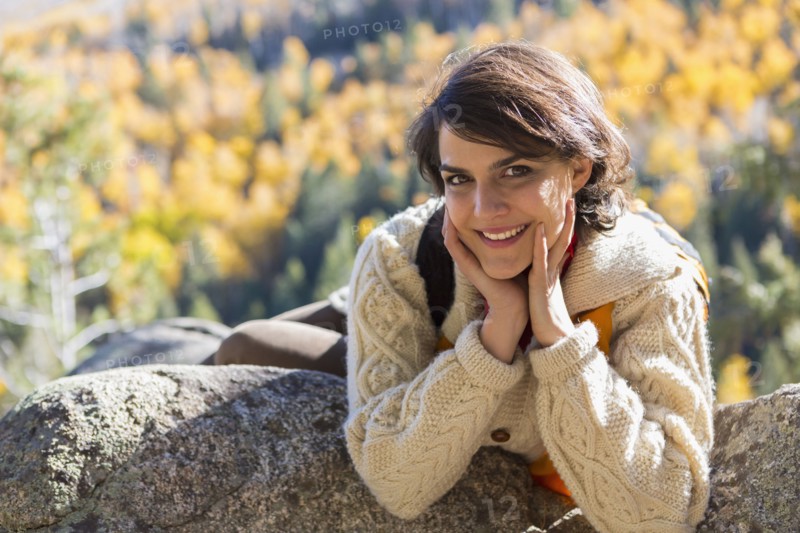 Mixed race woman smiling on rock