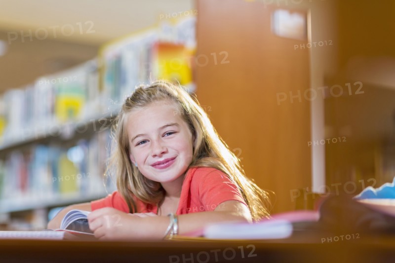 Caucasian student smiling at desk in library