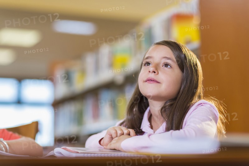 Mixed race student sitting at desk in library