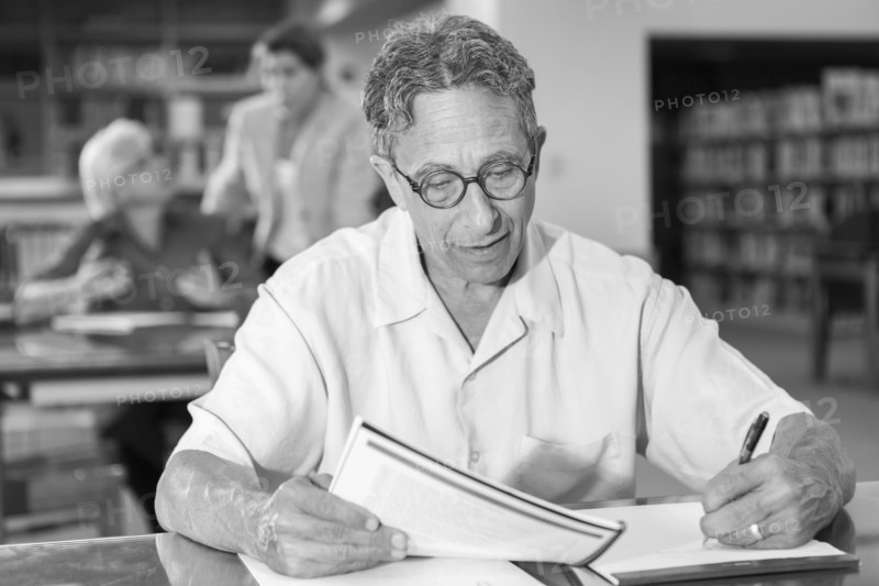 Caucasian man writing on notepad in library