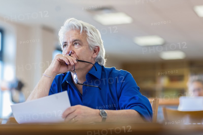 Man reading paperwork in library