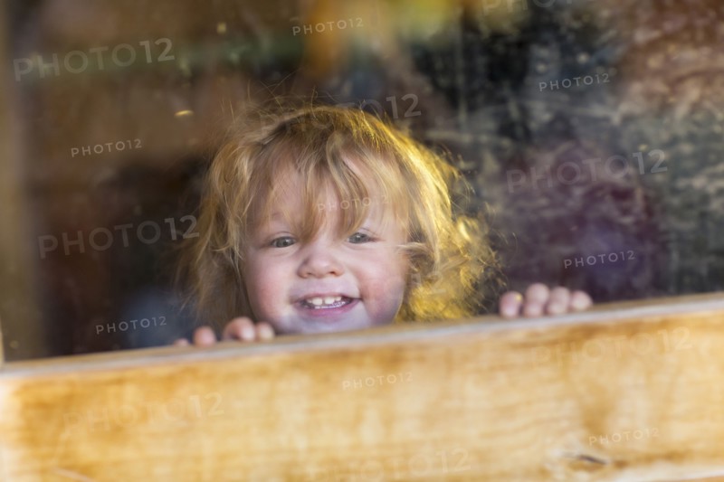 Caucasian baby smiling and looking out window