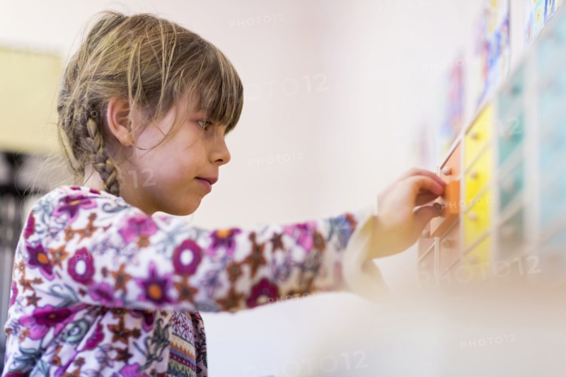 Close up of mixed race girl opening drawer in classroom