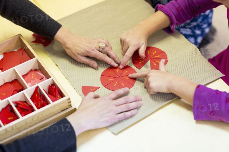 Close up of Caucasian Montessori teacher and student solving puzzle