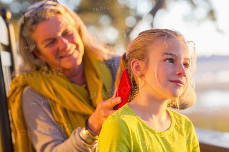 Caucasian grandmother brushing hair of granddaughter