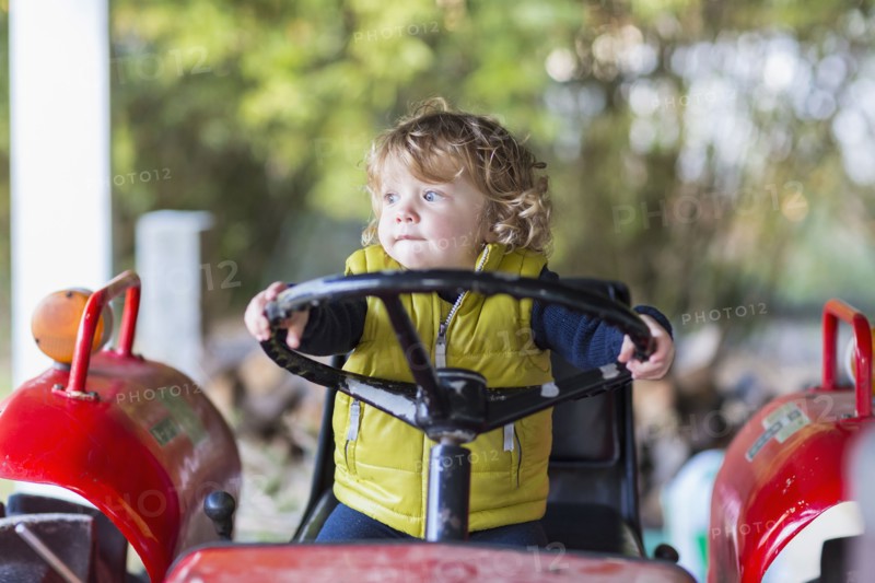 Caucasian baby boy driving tractor