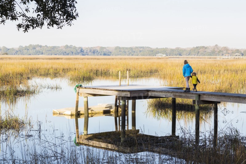 Caucasian children walking on wooden dock over lake
