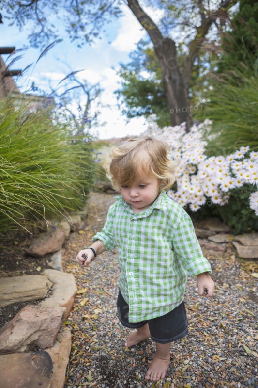 Caucasian baby boy walking in garden