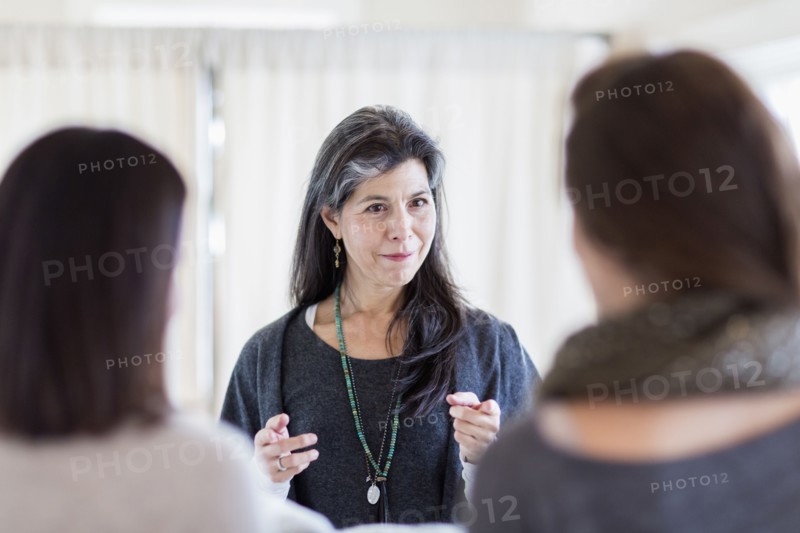 Small business owner talking to customers in store