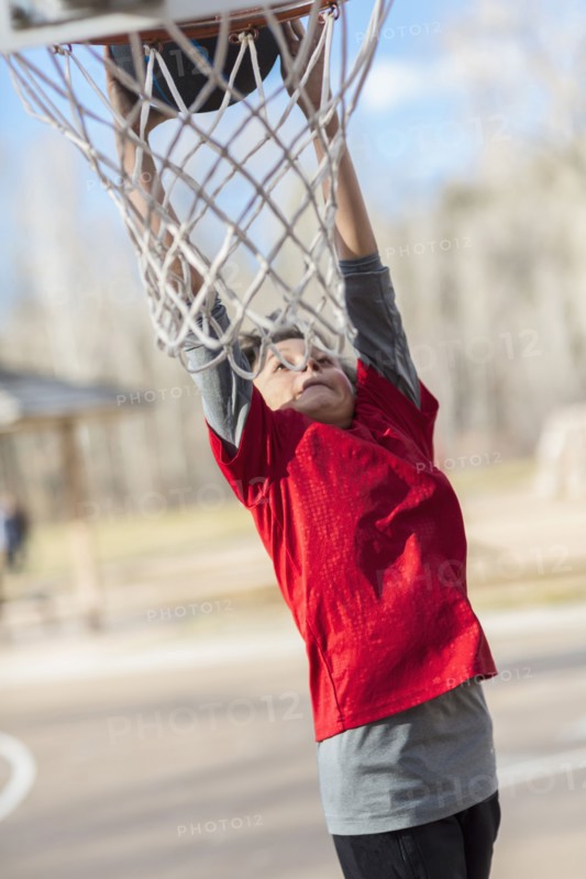 Caucasian boy playing basketball on court