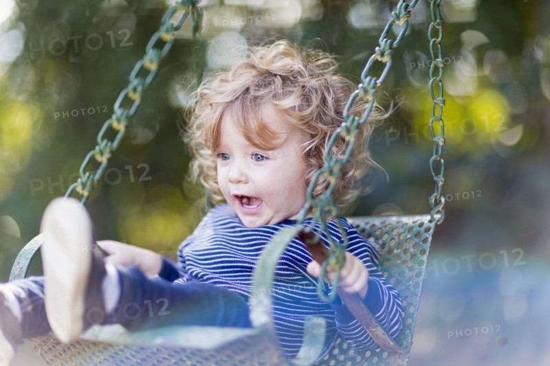 Caucasian baby boy sitting on swing