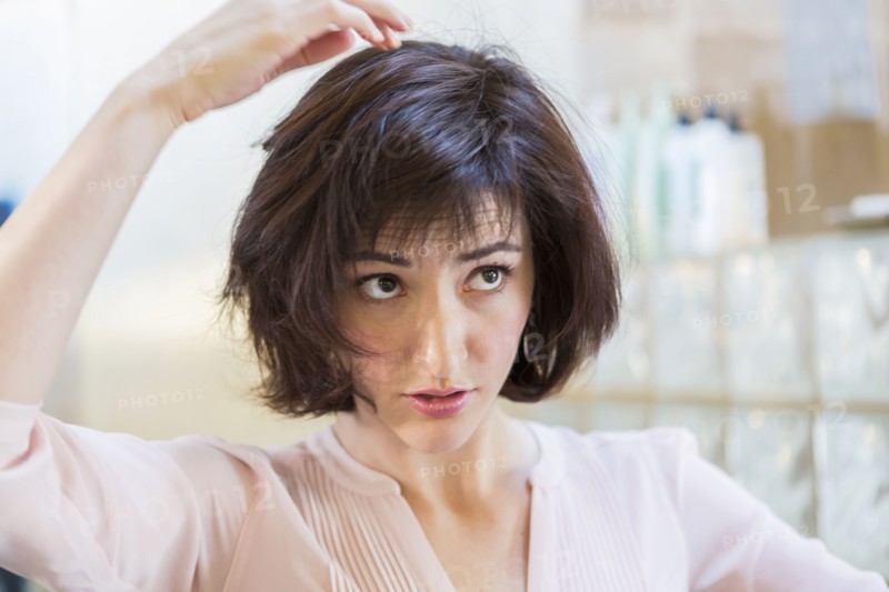 Close up of Hispanic woman examining her hair
