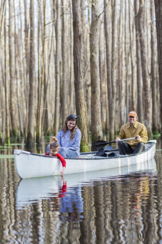 Family sitting together in canoe on river