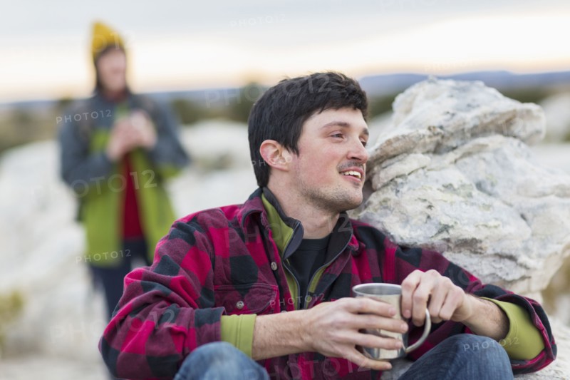 Couple drinking coffee on rock formations