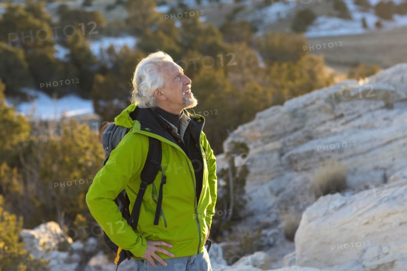 Older man standing on remote rock formations