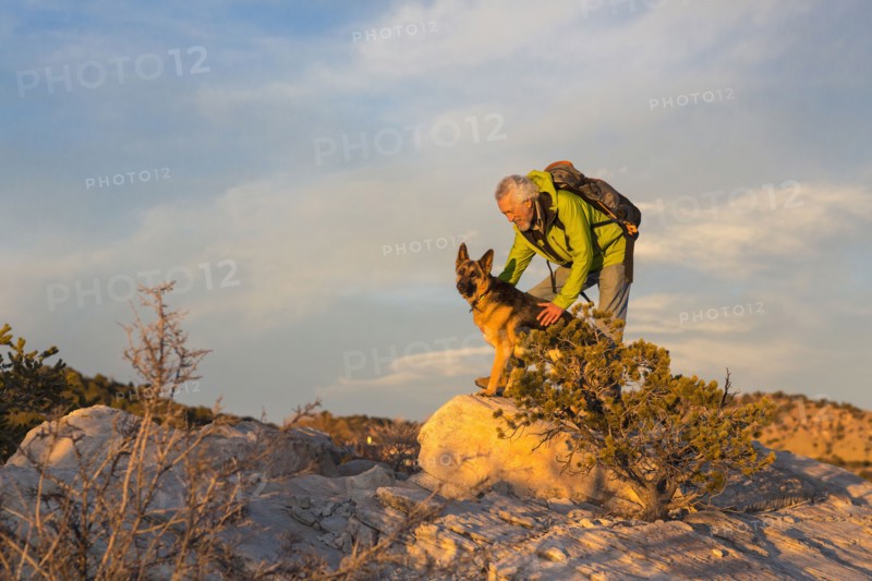 Older man and dog on remote rock formations