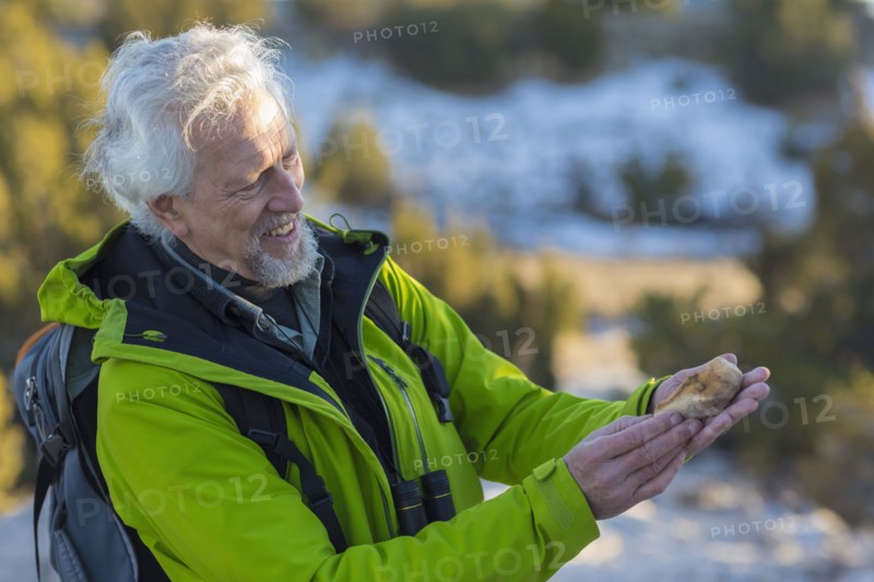 Older man admiring rock on hike