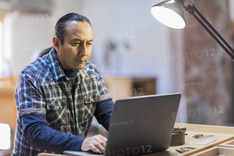 Native American artist using laptop in studio
